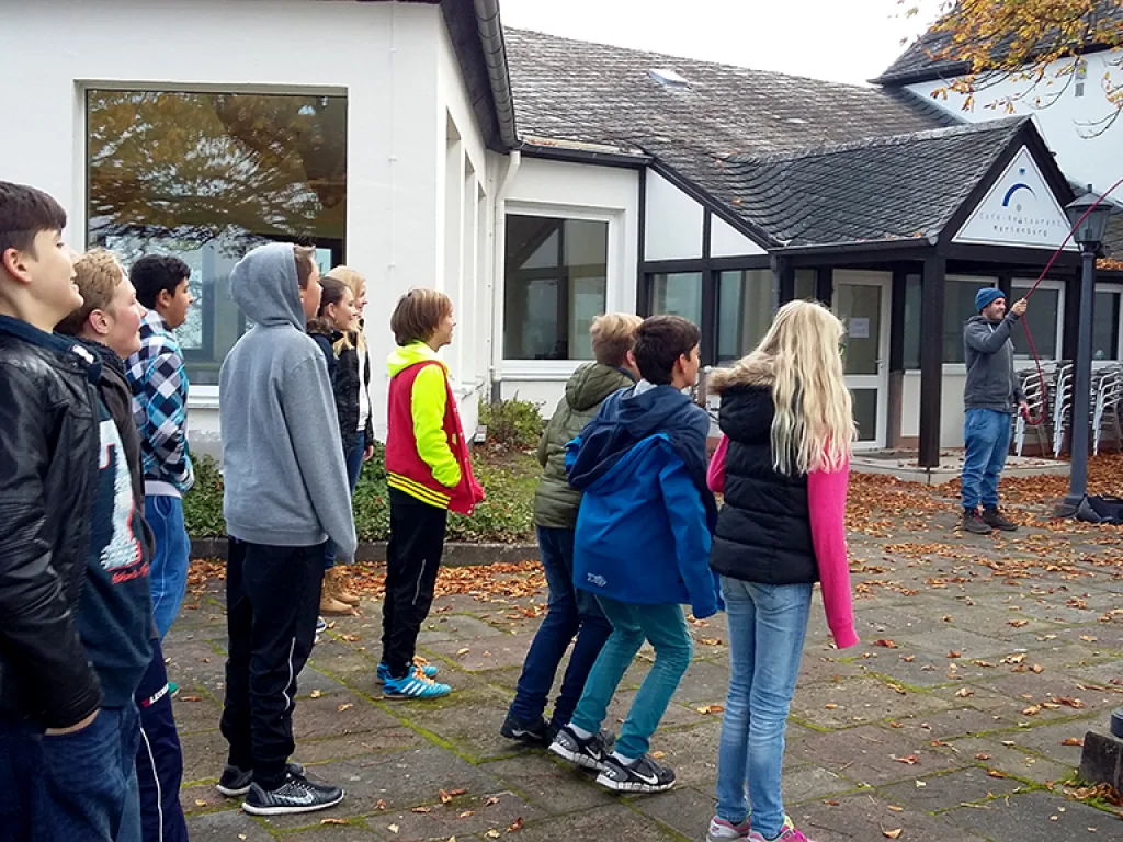 Gruppe steht im Kreis vor dem Gebäude.